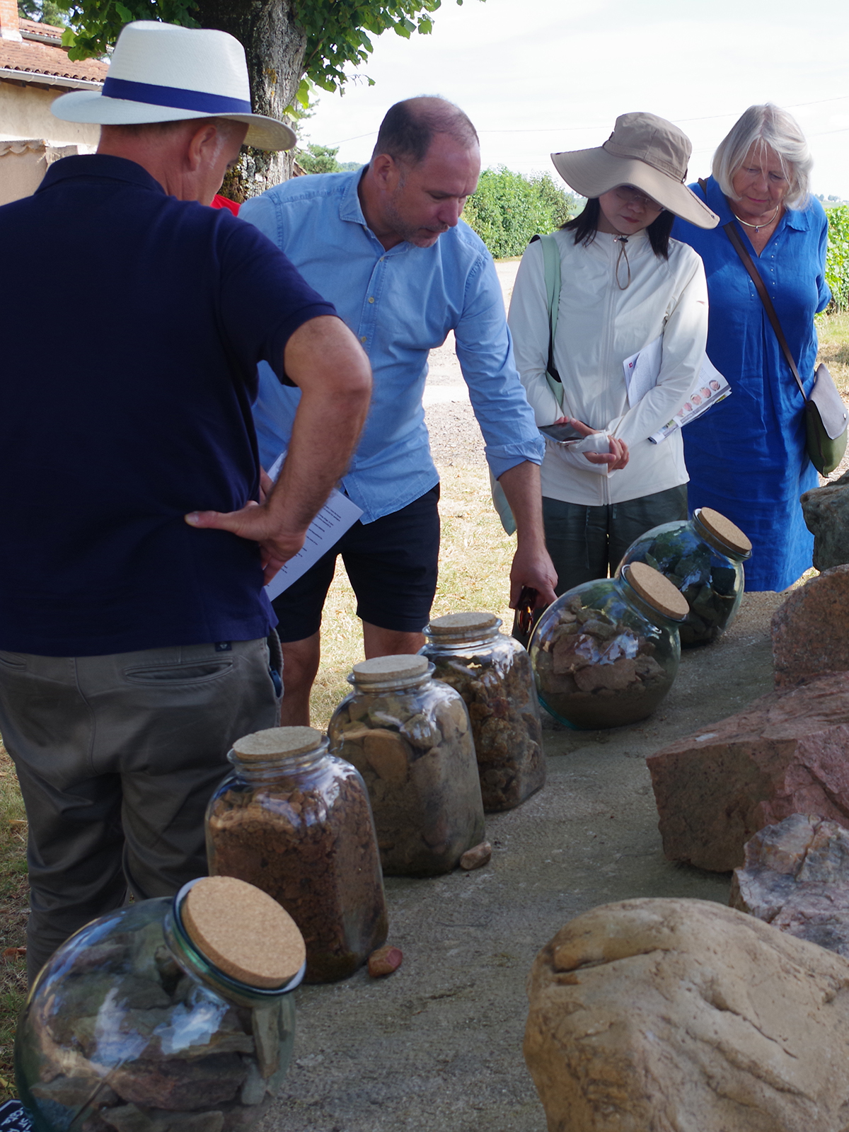 Vignerons et artisans du Beaujolais réunis dans une cour en pierres dorées